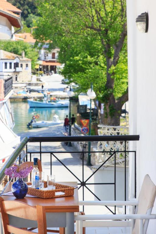 a table on a balcony with a view of a marina at Agora Apartment in Limenas