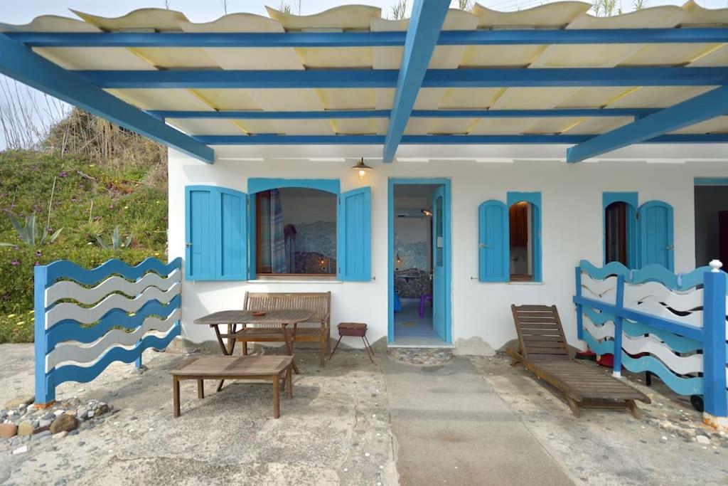 a blue and white house with two benches and a table at Azzurromare Residence in Procida