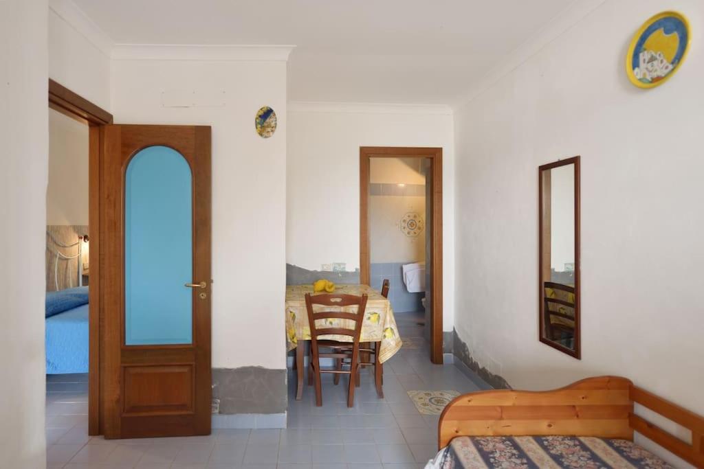 a room with a bedroom with a table and a dining room at Azzurromare Residence in Procida
