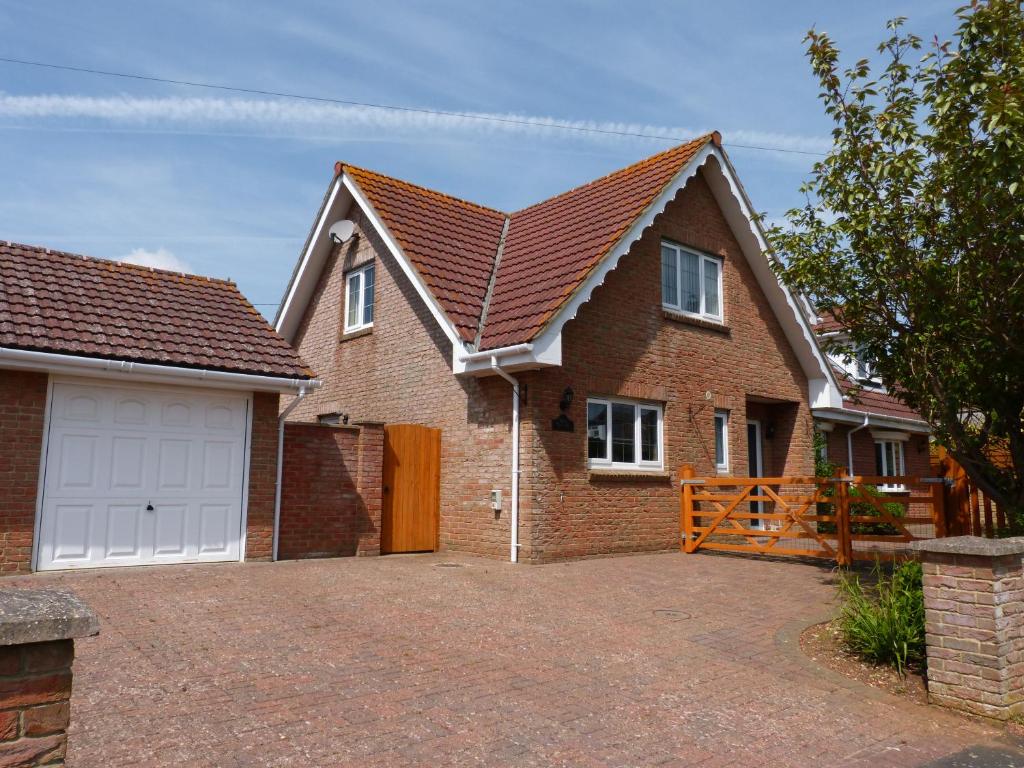 a brick house with a garage and a driveway at Hill Cottage in Newchurch