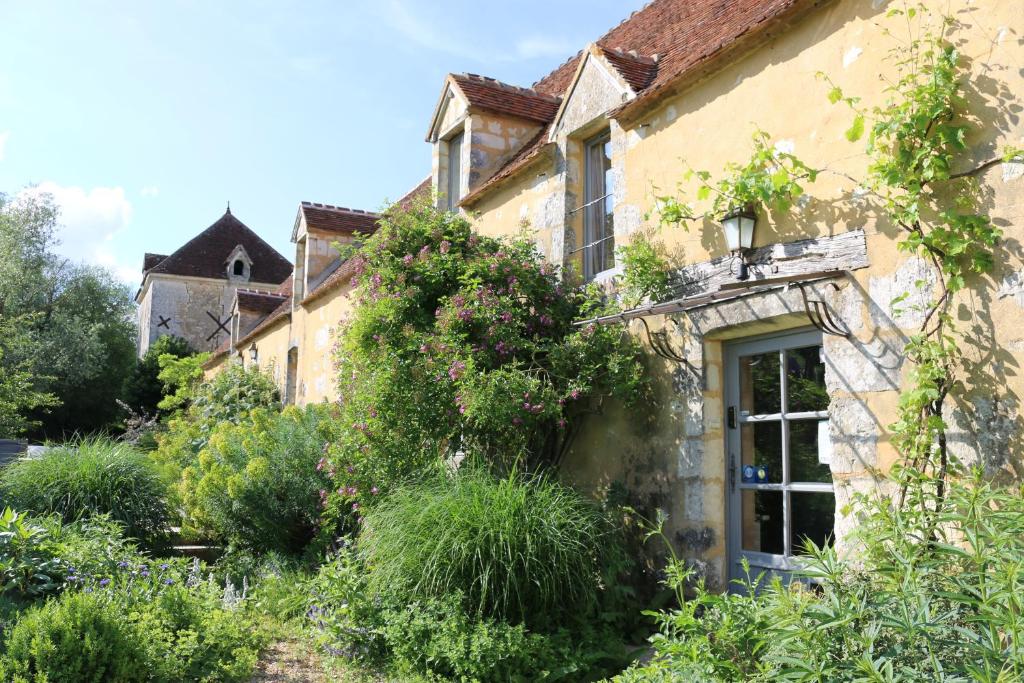 una casa antigua con un jardín delante de ella en Le bourgis en La Chapelle-Montligeon