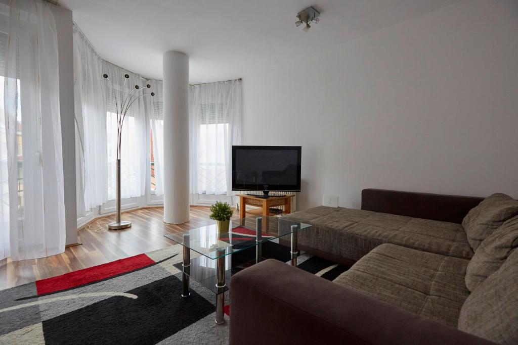 a living room with a couch and a flat screen tv at Optimum Home in Pécs
