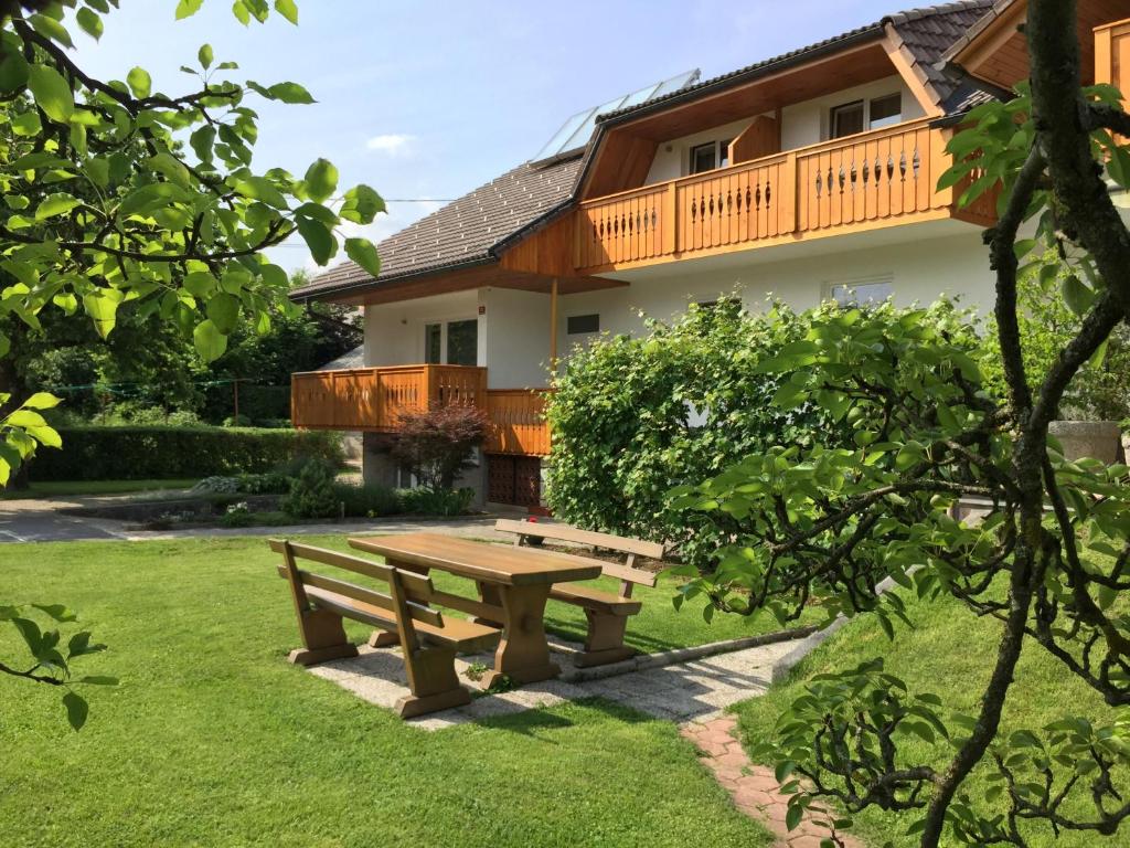 a wooden picnic table in front of a house at Apartments Kristan in Bled