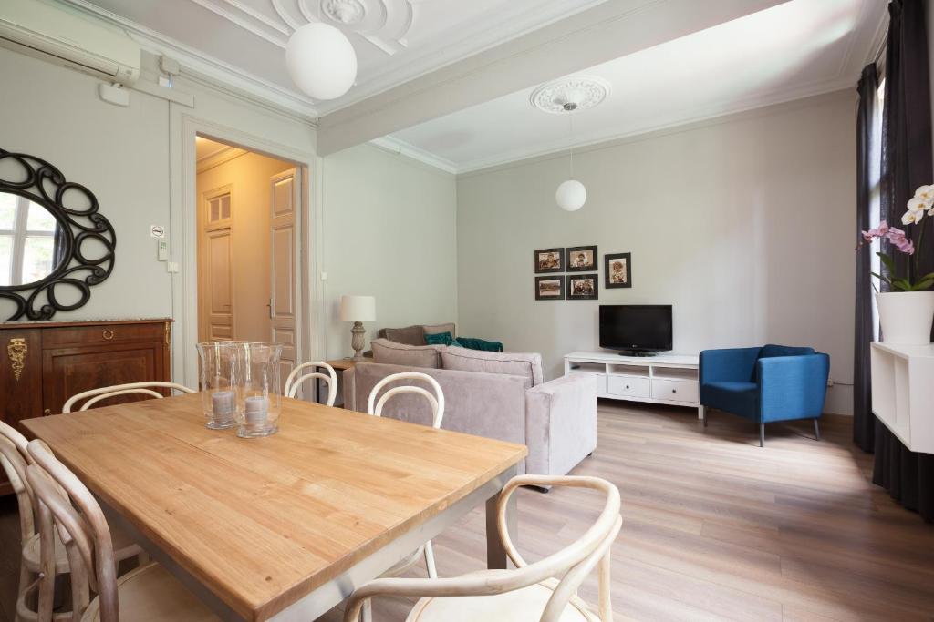 een woonkamer met een houten tafel en stoelen bij EasySleep Gaudi Terrace in Barcelona