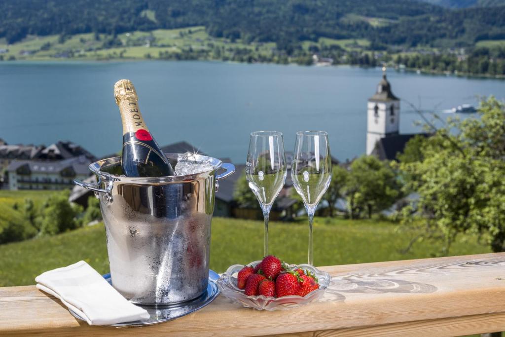 een emmer champagne en twee wijnglazen op een tafel bij Altroiterhof in St. Wolfgang