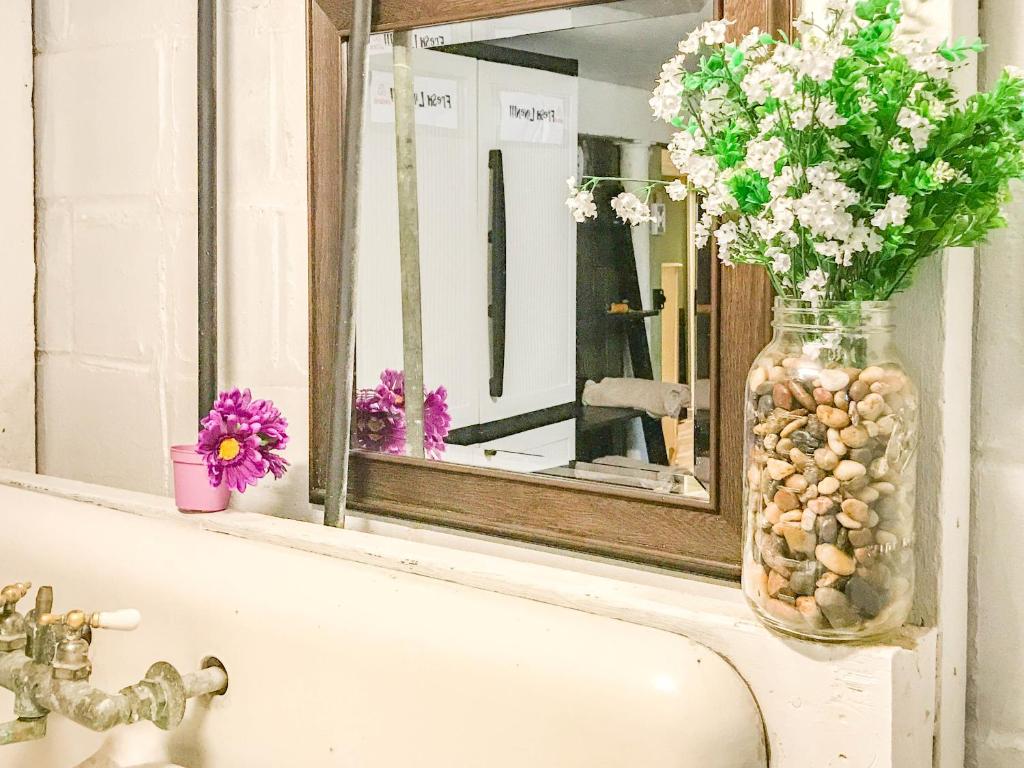 a bathroom sink with a vase of flowers and a mirror at Co-ed Dorm with Fantastic Patio! in Ewing