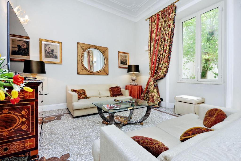 a living room with white furniture and a window at Popologrande Apartment in Rome