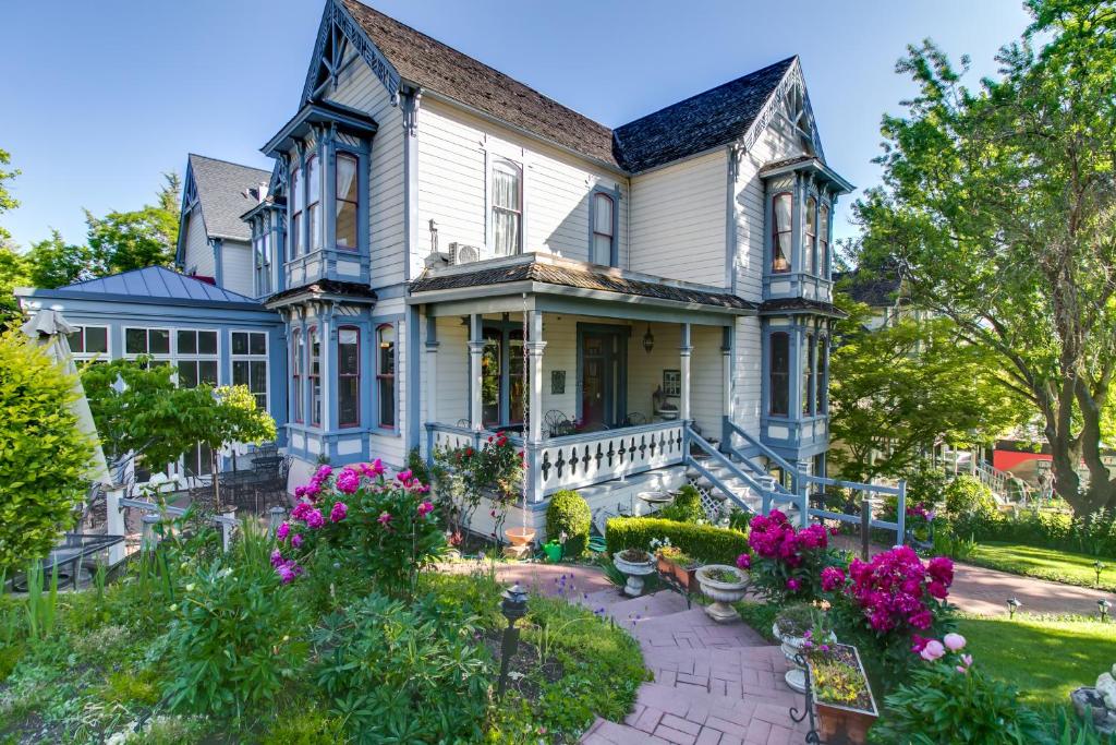 una casa vieja con flores en el patio en Winchester Inn en Ashland