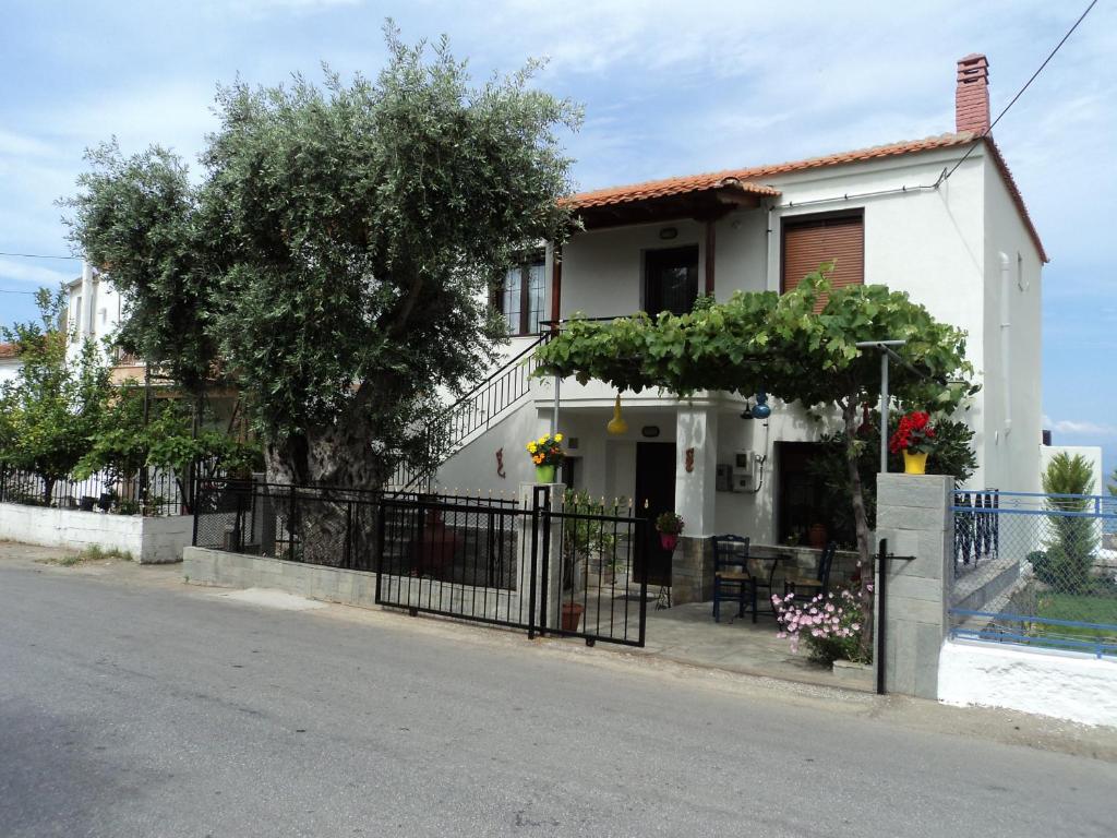 a white house with a fence and a tree at Aegean Balcony in Skala Kallirakhis