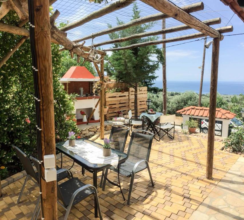 a patio with a table and chairs under a pergola at Lenti Street House in Kallirákhi
