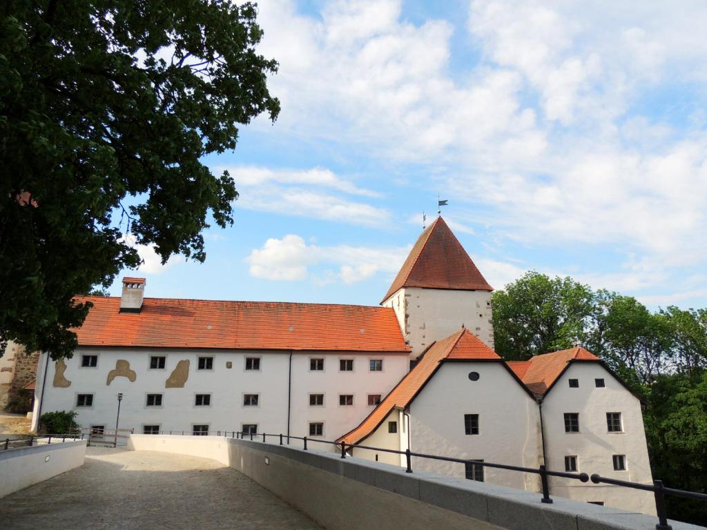 un gran edificio blanco con techo rojo en Gästehaus Mälzerei auf Schloss Neuburg am Inn, en Neuburg am Inn