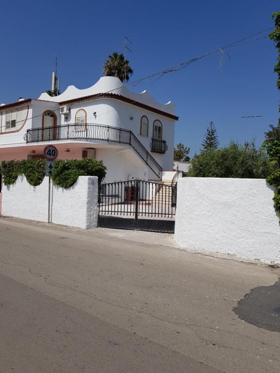 Casa bianca con balcone su una strada di DesyMar Inn a Fontane Bianche