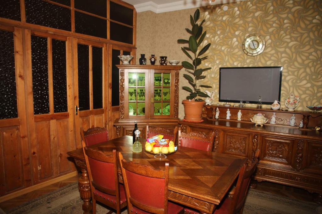 a dining room with a wooden table and a television at Hostel Saba in Kutaisi