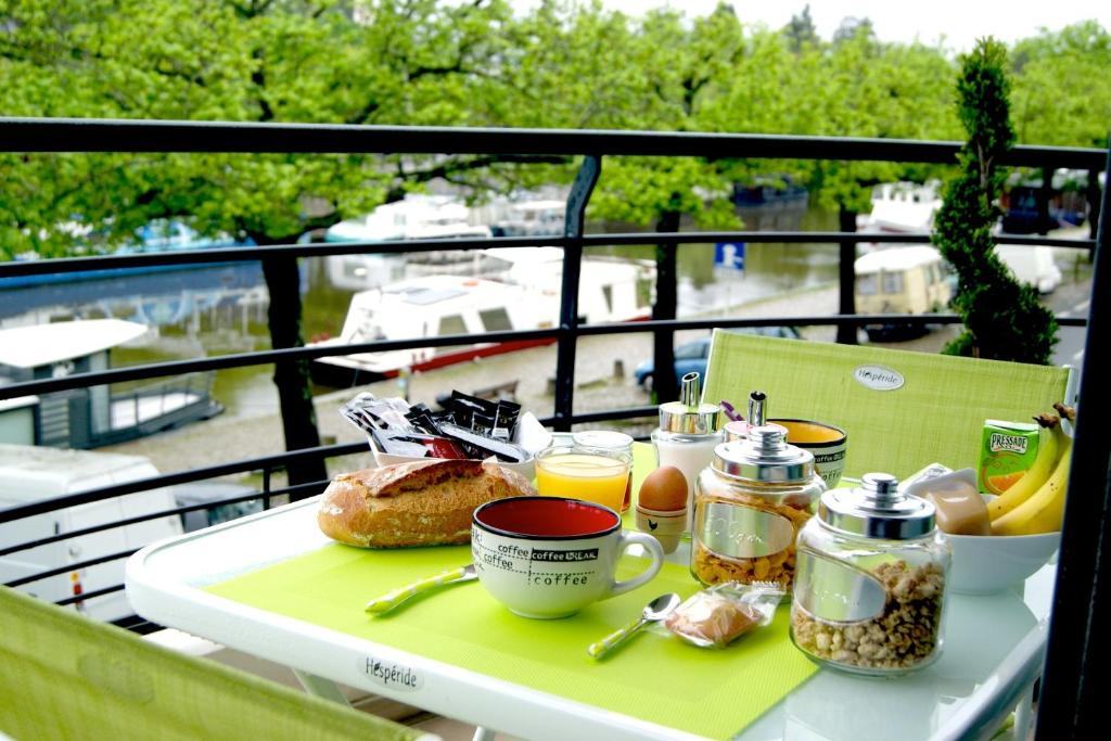 een tafel met een dienblad met ontbijtproducten op een balkon bij L'Erdream in Nantes