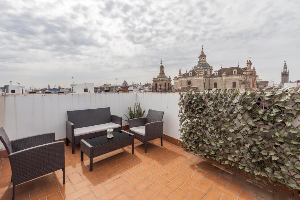 a balcony with chairs and a table and a fence at Apartamentos Cuna 41 in Seville