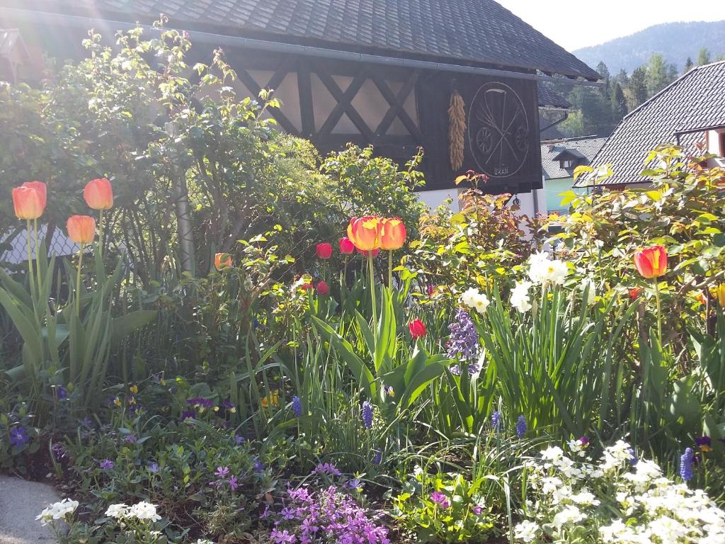 een tuin met kleurrijke bloemen en een prieel bij Turistična kmetija Žerovc in Bled