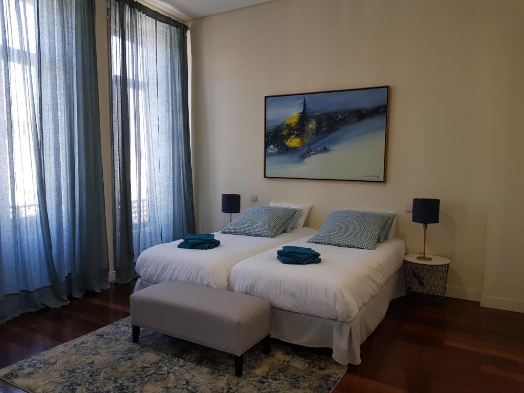 two beds in a room with two large windows at OHH - Porto Boutique Guest House in Porto