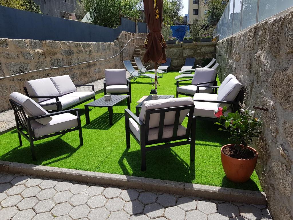 een groep stoelen en tafels op een gazon bij OHH - Porto Boutique Guest House in Porto