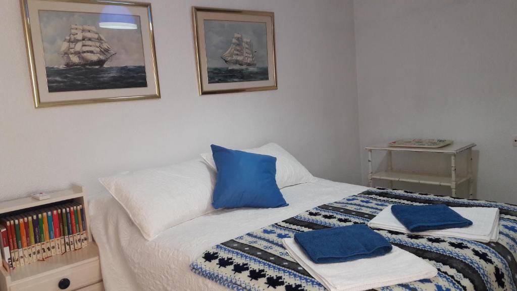 a bedroom with a bed with blue pillows on it at Casa Nadin in Alicante