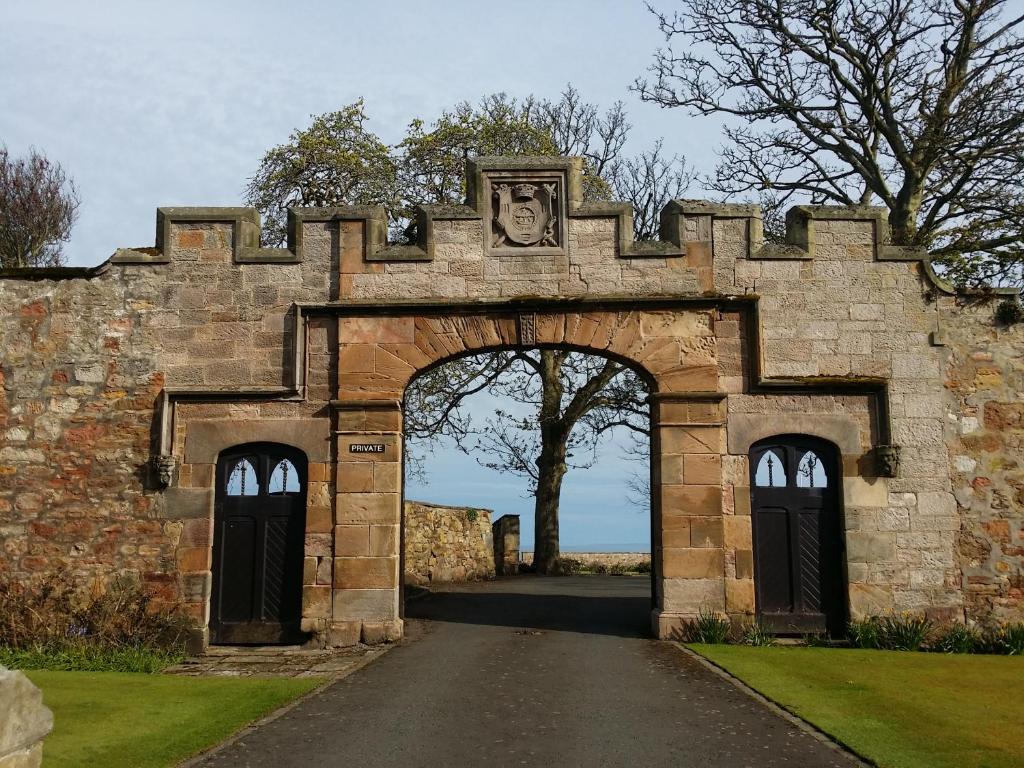an entrance to a stone building with an archway at Crail House Apartments in Crail