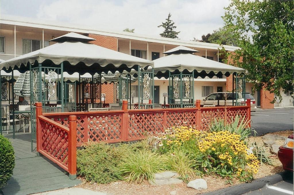 une clôture orange avec des tables et des parasols devant un bâtiment dans l'établissement Meadow Court Inn - Ithaca, à Ithaca