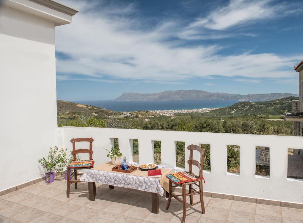 Una mesa y sillas en un balcón con vista al mar. en Kyparissos Apartment I, en Kissamos
