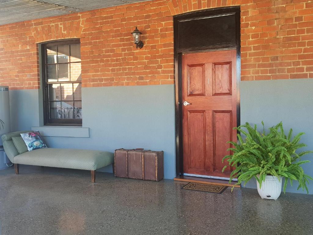 a red door and a bench next to a brick building at Sublime Spa Apartments in Wangaratta