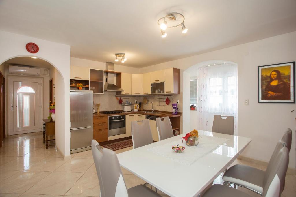 uma cozinha e sala de jantar com uma mesa branca e cadeiras em Apartment Marijeta em Split
