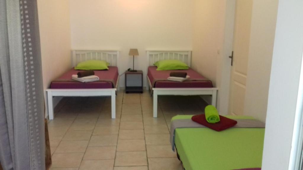 two beds in a room with green and red at Ilet Blanc in Sainte-Rose