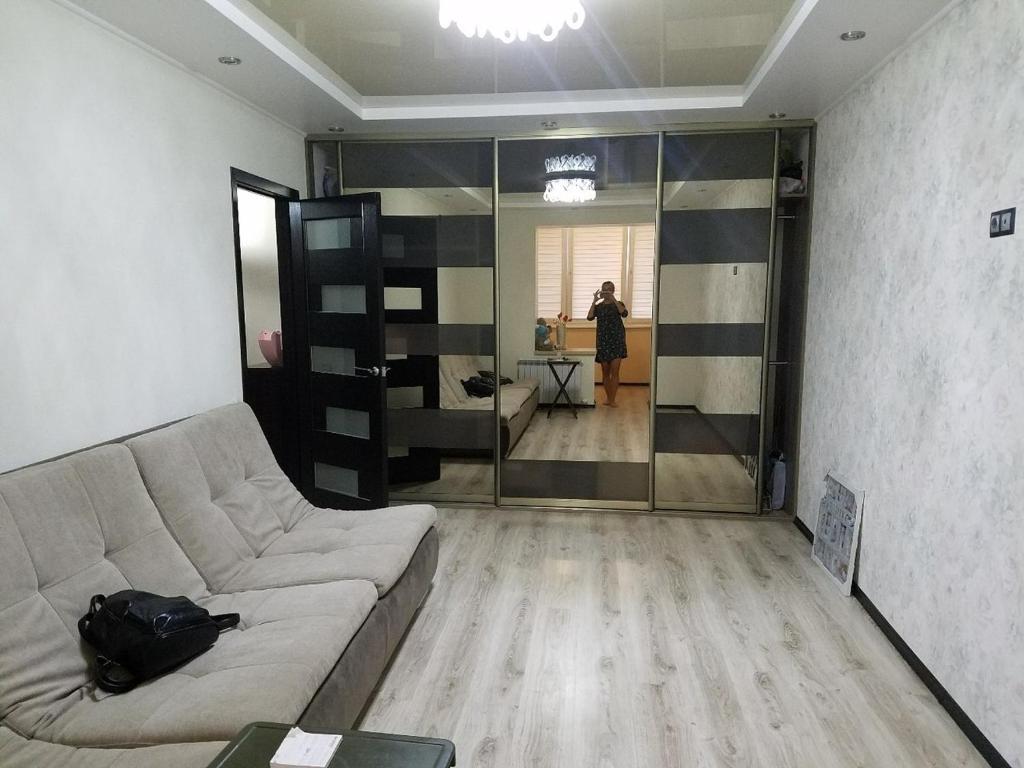 a living room with a couch and a person in the background at Квартира in Tiraspol