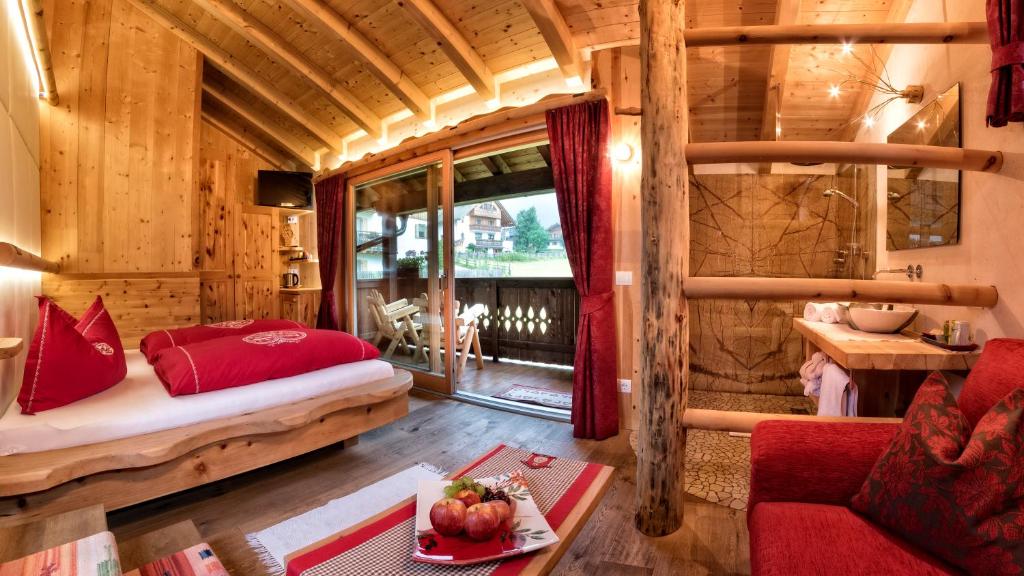 a bedroom in a log cabin with a bed and a table at La Ücia by Fana Ladina in San Vigilio Di Marebbe
