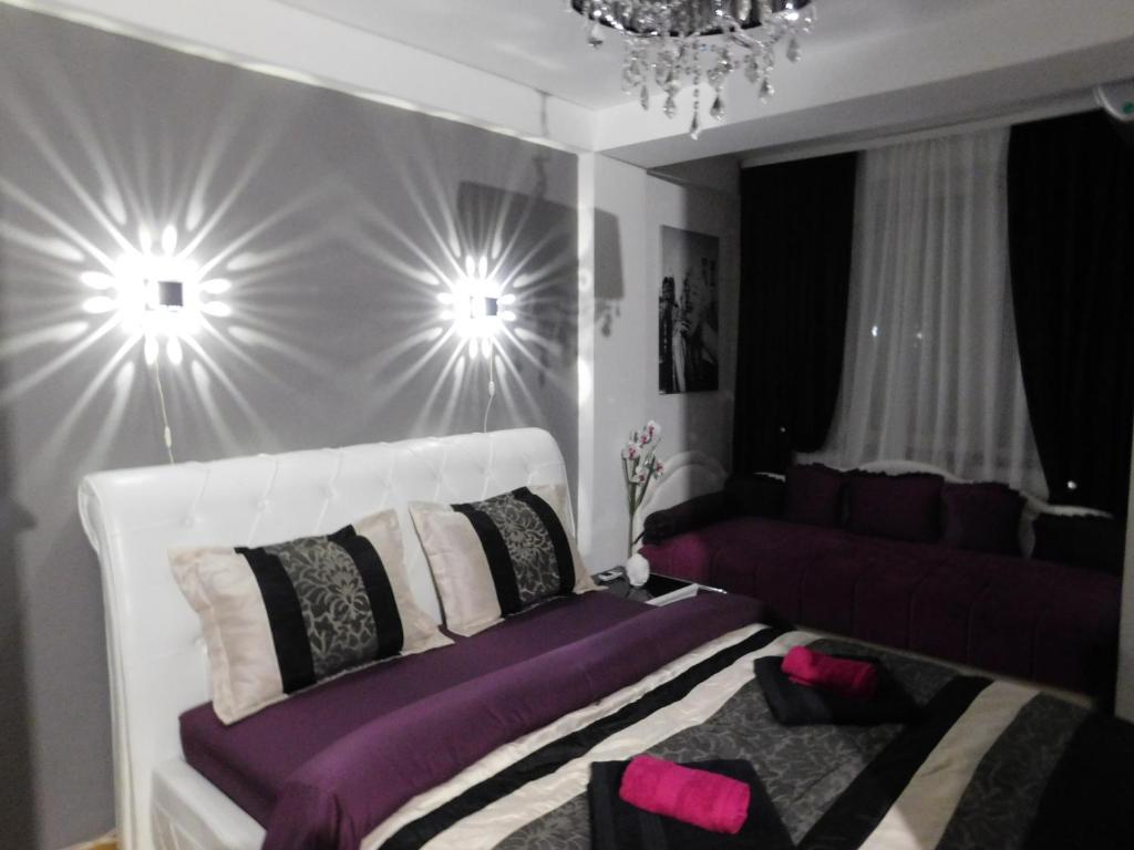 um quarto com uma cama e um sofá em Velvet Lux Apartment em Niš