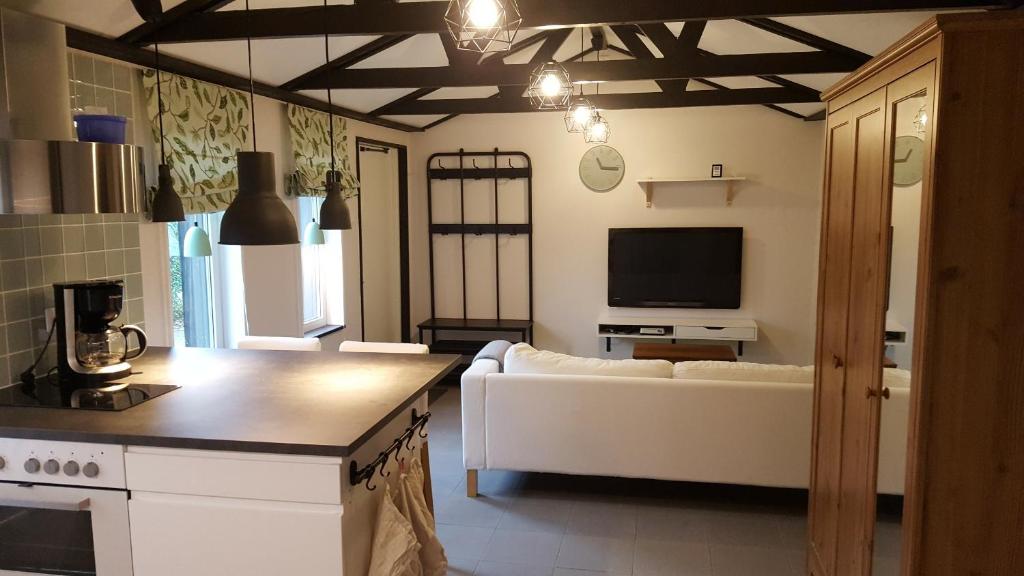 a living room with a white couch and a tv at Cozy home in between Malmö & Lund in Åkarp