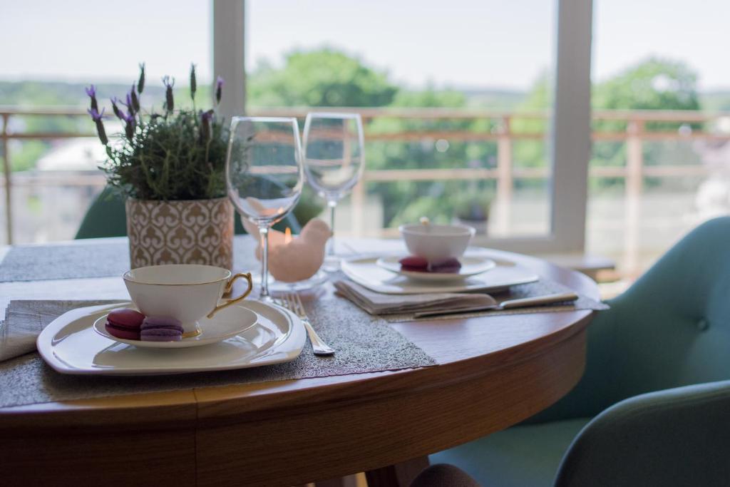 德拉肯恩凱的住宿－Penthouse，木桌,带两杯酒杯和植物