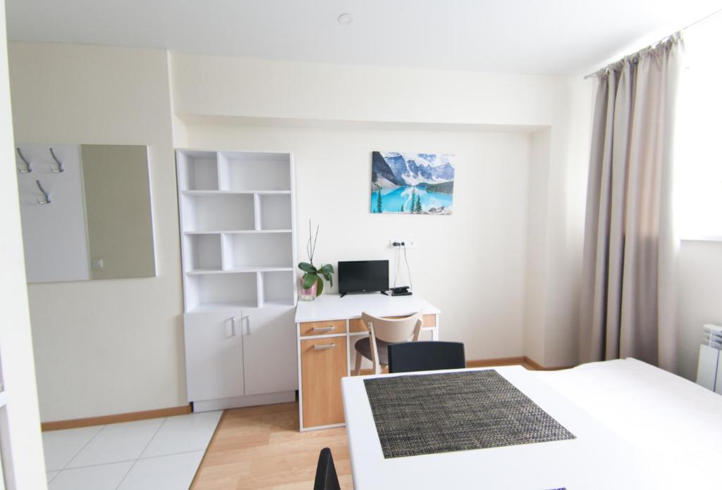 a white bedroom with a bed and a desk at EasyStay inn in Kyiv