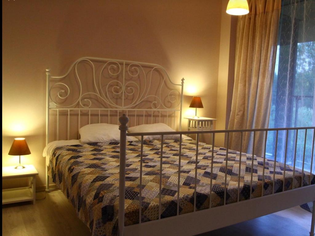 - une chambre avec un grand lit et une tête de lit en fer forgé dans l'établissement Welcome Sun Republic Apartments, à Saulkrasti