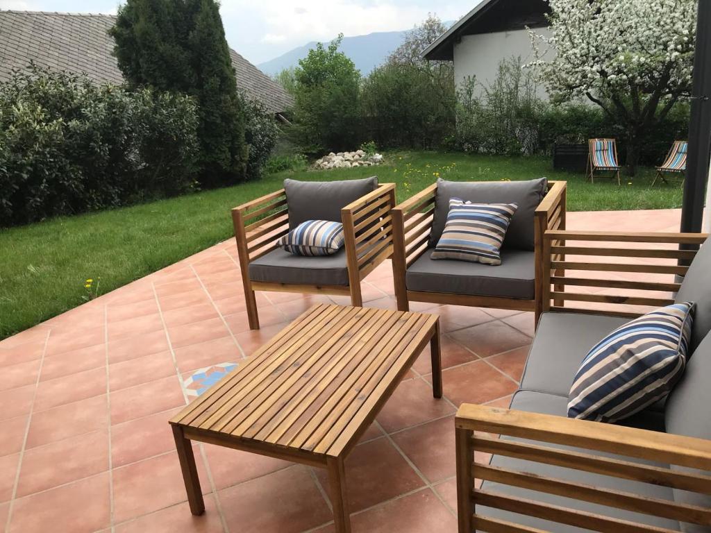 a patio with three chairs and a table and benches at Villa Dei Sogni in Bled