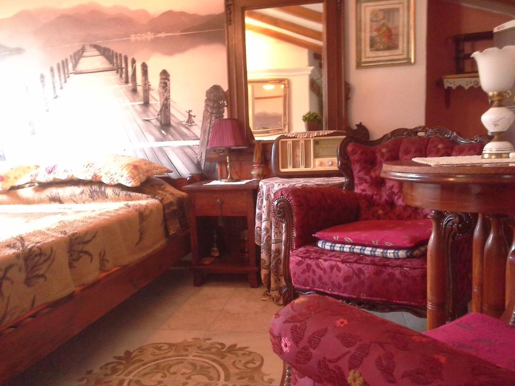 a bedroom with a bed and a chair and a table at Studios Kono in Kotor