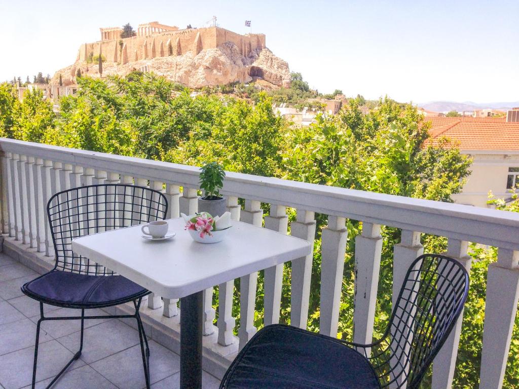 a white table and chairs on a balcony with a view of a castle at Athens Grand Suite in Athens