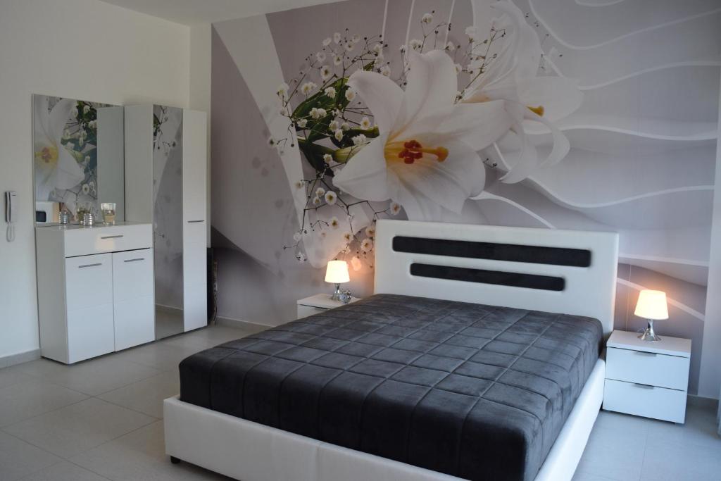a bedroom with a bed with flowers on the wall at Kristina Apartments in Tivat