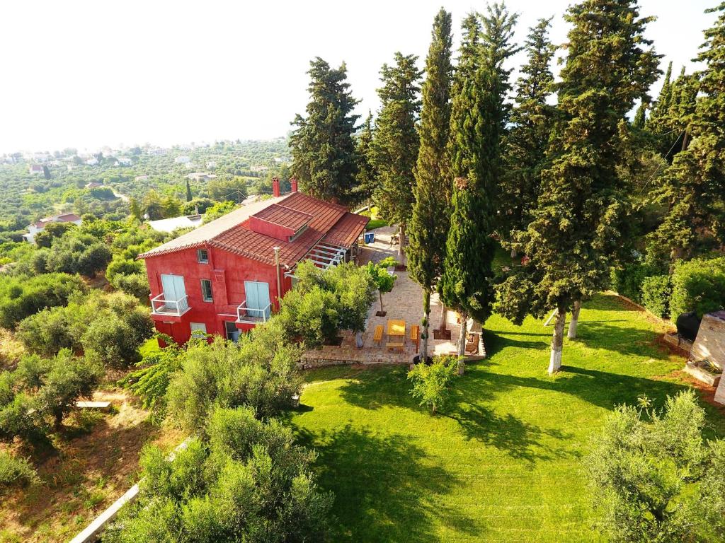 an aerial view of a red house on a green yard at Sea View Villa with 4 bedrooms - grECOrama in Monodhéndrion