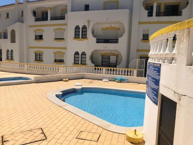 a swimming pool in front of a large building at Cardoso Beirao in Carvoeiro