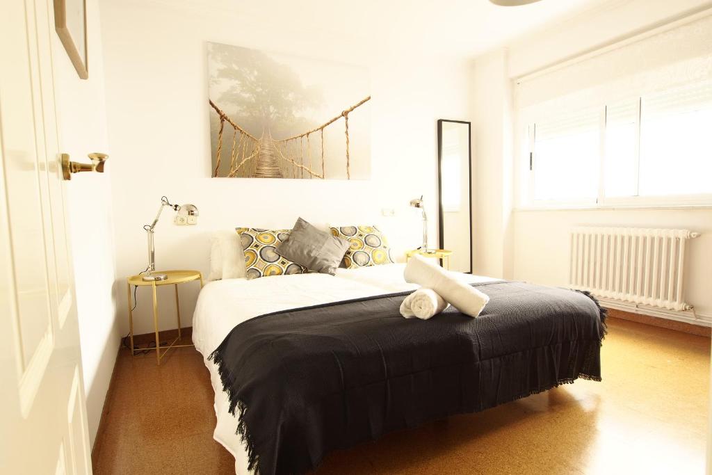 una camera da letto bianca con un letto con una coperta nera di APART XXlll 24h CATEDRAL Garaje a Santiago de Compostela