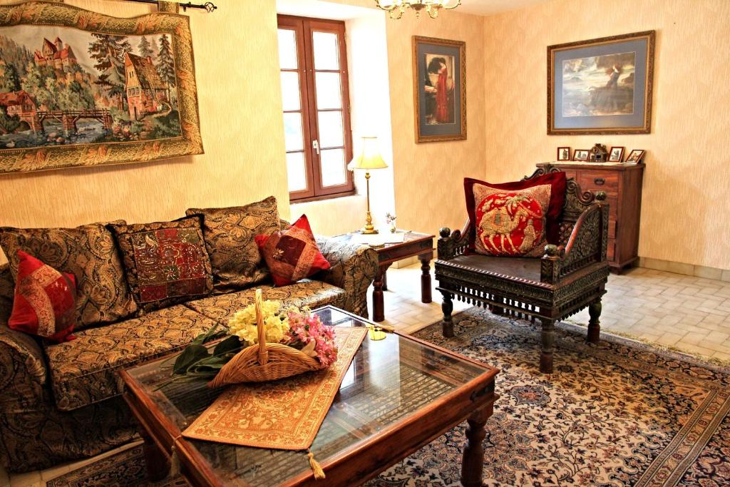 ein Wohnzimmer mit einem Sofa und einem Couchtisch in der Unterkunft The Storyteller Apartment at Chateau Le Mur in Carentoir