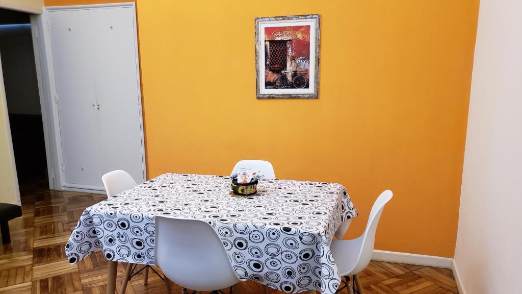 uma sala de jantar com uma mesa e cadeiras brancas em Departamento Obelisco em Buenos Aires