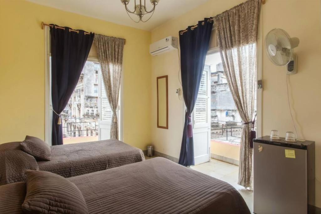 1 dormitorio con 2 camas y ventana en Casa Yaque, en La Habana