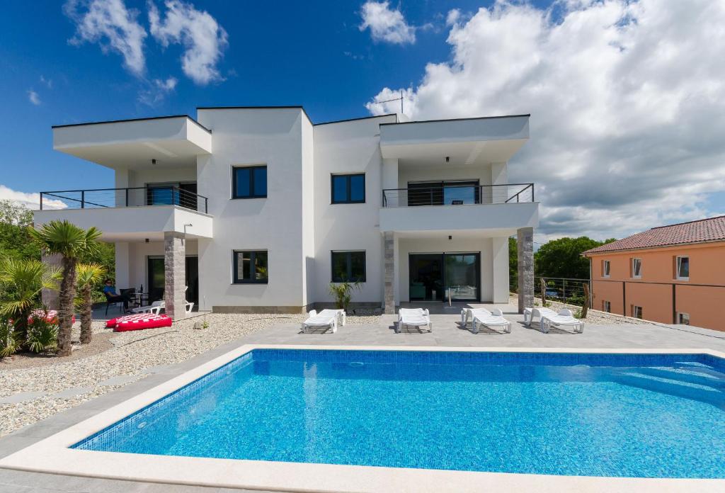 a villa with a swimming pool in front of a house at Apartments Residence Romance in Pinezici