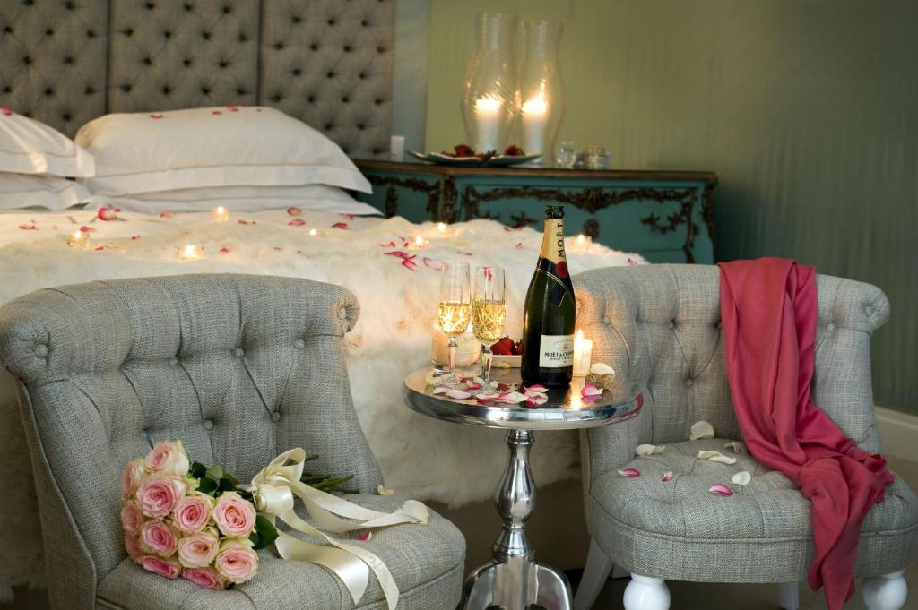 ナザレにあるRicky GuestHouseのベッドルーム1室(ベッド1台、椅子2脚、シャンパン1本付)