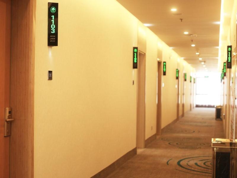 a hallway in a building with signs on the wall at GreenTree Inn Suzhou Yongqiao District Fuxiao Avenue Hotel in Suzhou