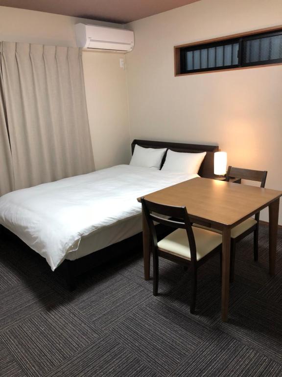 a hotel room with a bed and a table at Kyogura Bettei Nijo in Kyoto